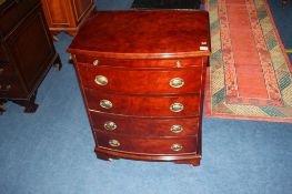 A reproduction bow front chest of drawers, with brushing slide, 64cm wide