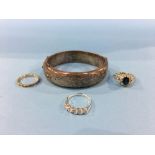 A silver bangle and three rings
