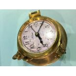 A brass Solent Quartz clock in the shape of a porthole