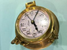 A brass Solent Quartz clock in the shape of a porthole