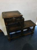 A carved oak tiered table with single drawers