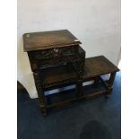 A carved oak tiered table with single drawers