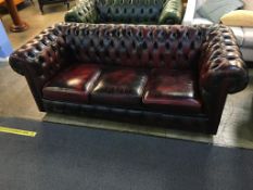 An oxblood Chesterfield three seater settee