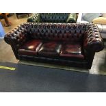 An oxblood Chesterfield three seater settee