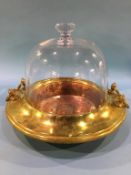 A glass dome Cloche over a copper brass base