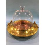 A glass dome Cloche over a copper brass base