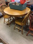 A circular breakfast table and four chairs and another set of four pine chairs