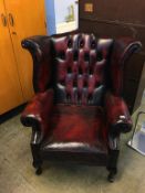 An oxblood Chesterfield leather high back armchair