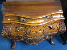 A reproduction serpentine three drawer carved commode chest, 97cm wide