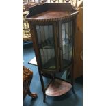 An Edwardian mahogany standing corner cabinet with lead glass door