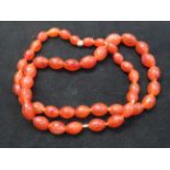 A string of 47 amber beads each bead with many inc