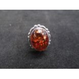 Silver dress ring set with large amber stone