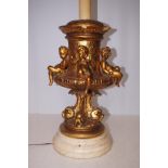 Large gilt cherub lamp on a marble base, chips to