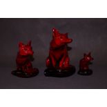 Three Royal Doulton, flambé sitting foxes