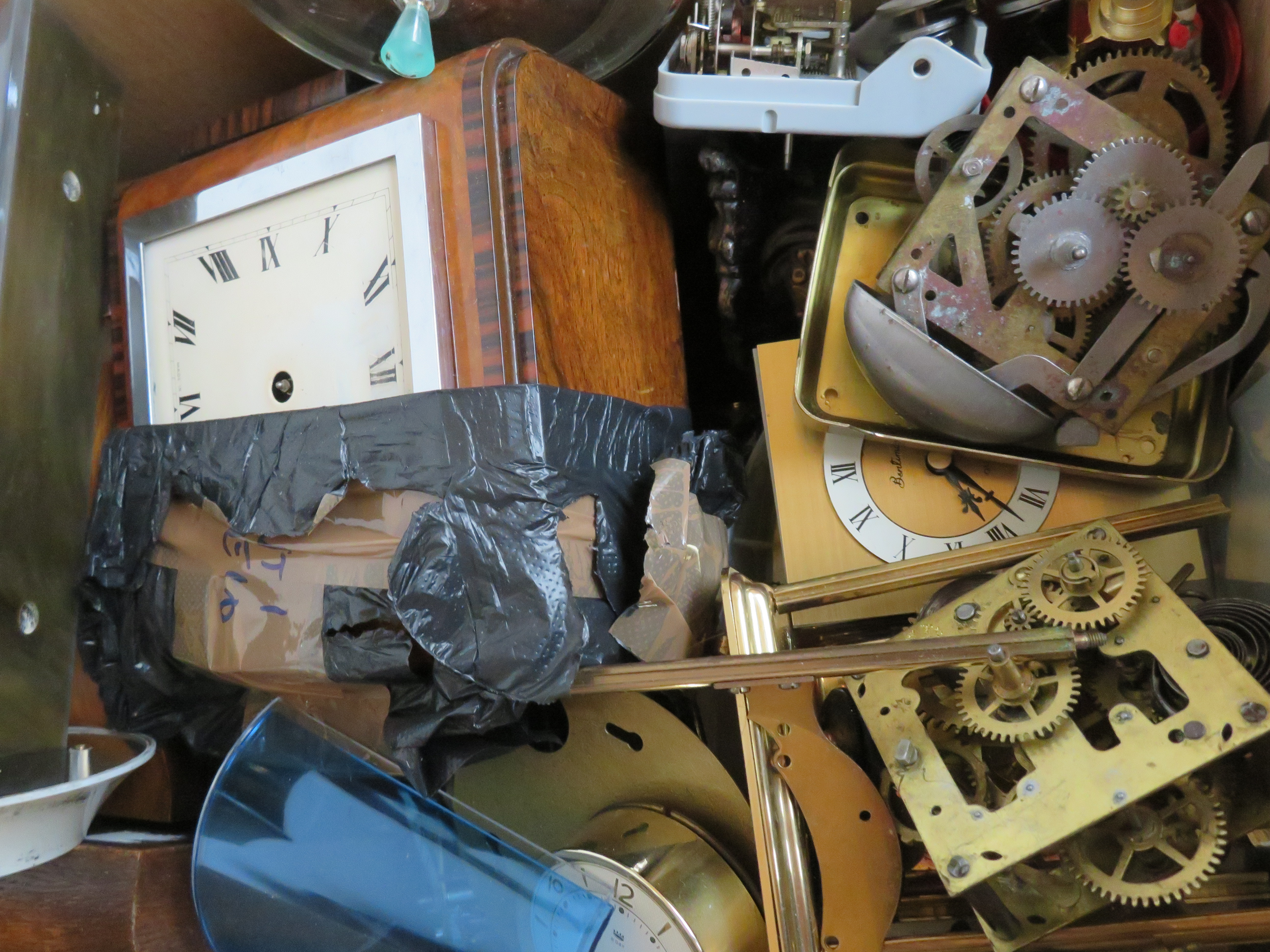 A box of clock parts for spares and repair