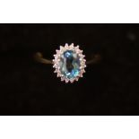 9ct Gold ring set with large blue topaz surrounded