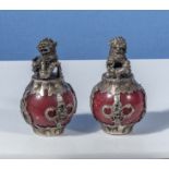 A pair of Chinese silvered metal temple dogs sitting on marble spheres, 3" high