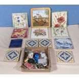 A collection of decorative tiles and a box of key rings