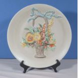 A Clarice Cliff charger decorated with a basket of flowers