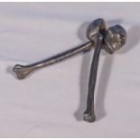 A pair of cast iron skull and cross bones nut crackers