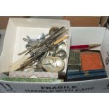 A box containing boxed and loose cutlery