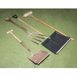 A snow shovel, brush, garden fork and shovel