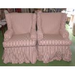 A pair of wing back over stuffed armchairs