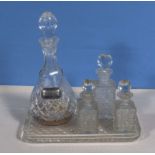 A glass decanter, three crystal perfume bottles and a tray