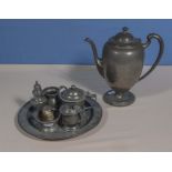 A pewter coffee pot together with a plate and condiment pieces