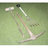 A pickaxe, garden fork and brush