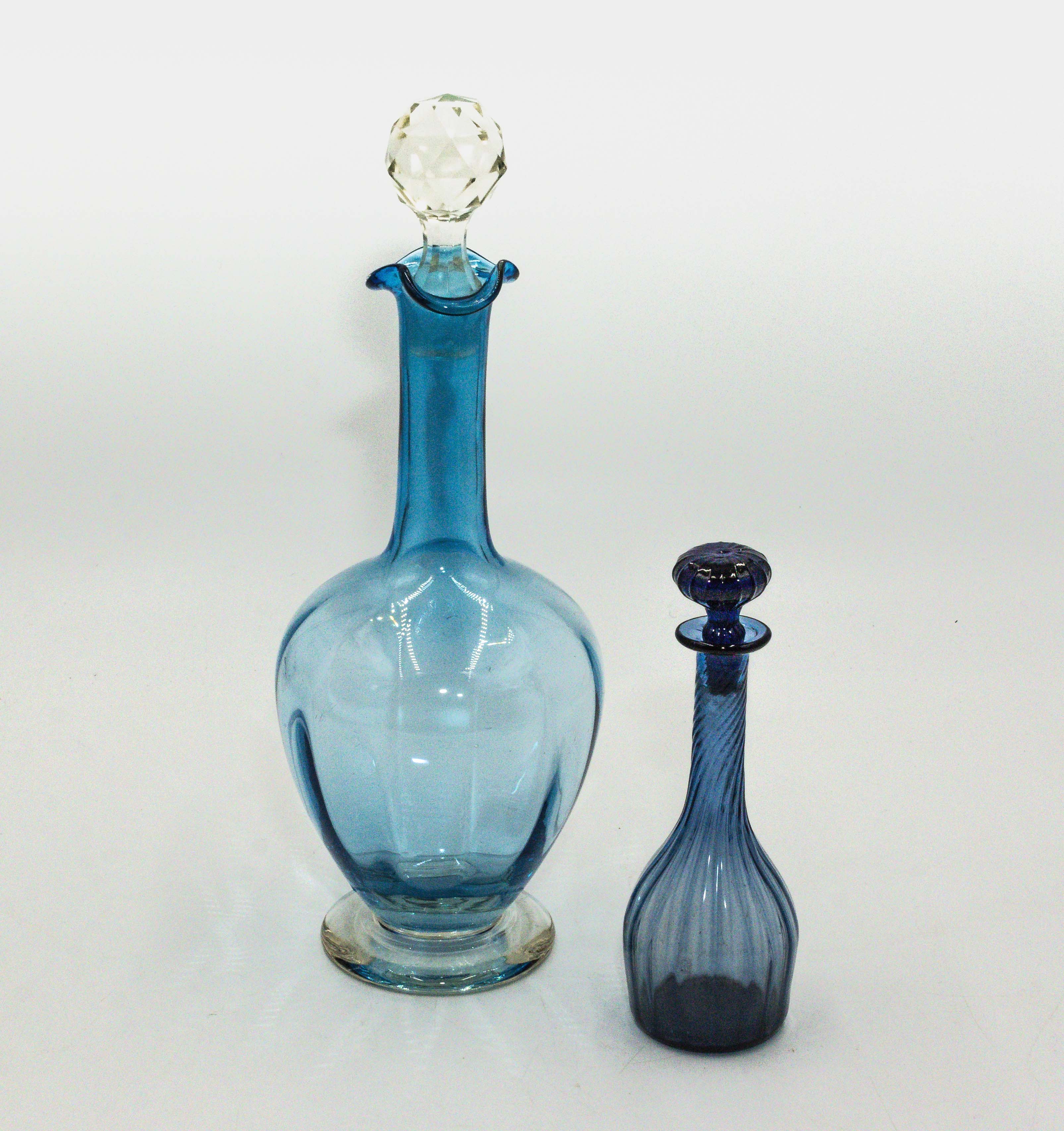 A blue glass decanter and a small scent bottle