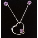 A silver floating heart pendant on curb chain set with pink stones with matching earrings