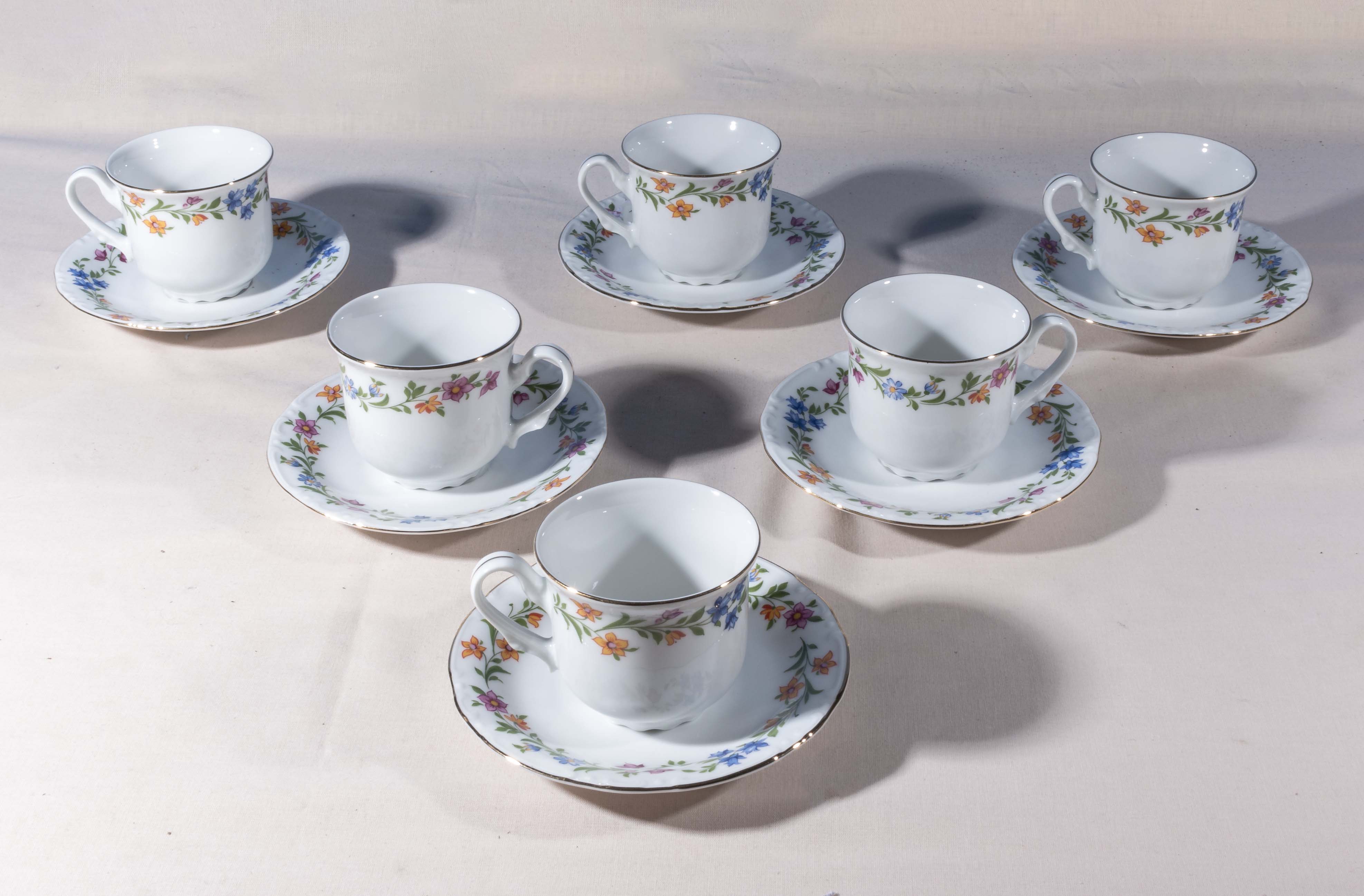 Six decorative china teacups and saucers