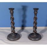 A pair of oak barley twist candlesticks