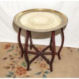 A Benares table, folding base with brass/copper top