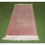 A pink ground wool rug, 154cm x 78cm
