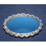 A Turkish antique silver Ottoman embossed wedding mirror of oval shape with silver chain, finely