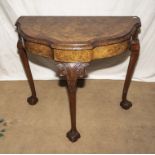 A walnut demi lune hall table with claw and ball feet, 76cm tall x 82cm wide x 44cm deep