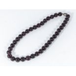 A cherry amber coloured lucite 1930's bead necklace, made in France, 17" in length