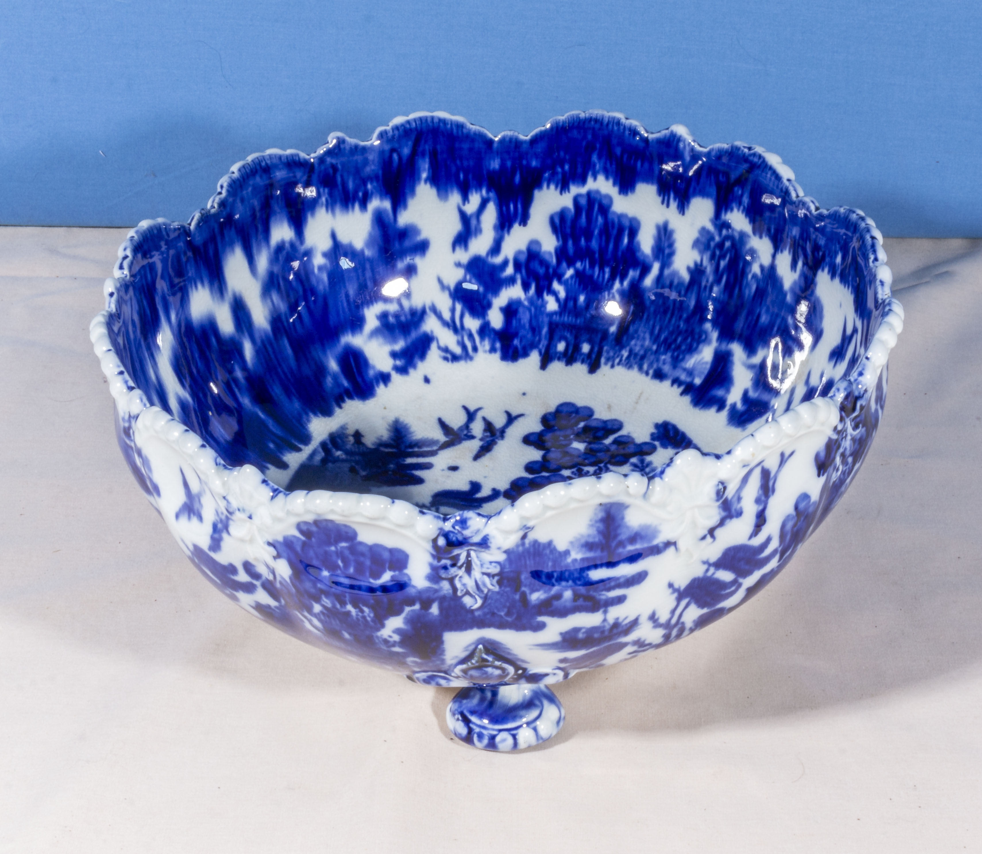 A flow blue pottery three footed bowl, 25cm diameter