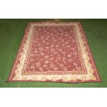 A red and cream ground wool rug, 165cm x 120cm