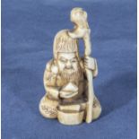An antique netsuke depicting a sage with a staff, 1.25"