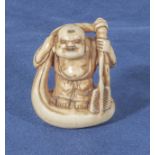 An antique netsuke of a man on a raft, 1.25"