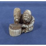 An antique Japanese netsuke depicting a woman threshing rice, 1.25"