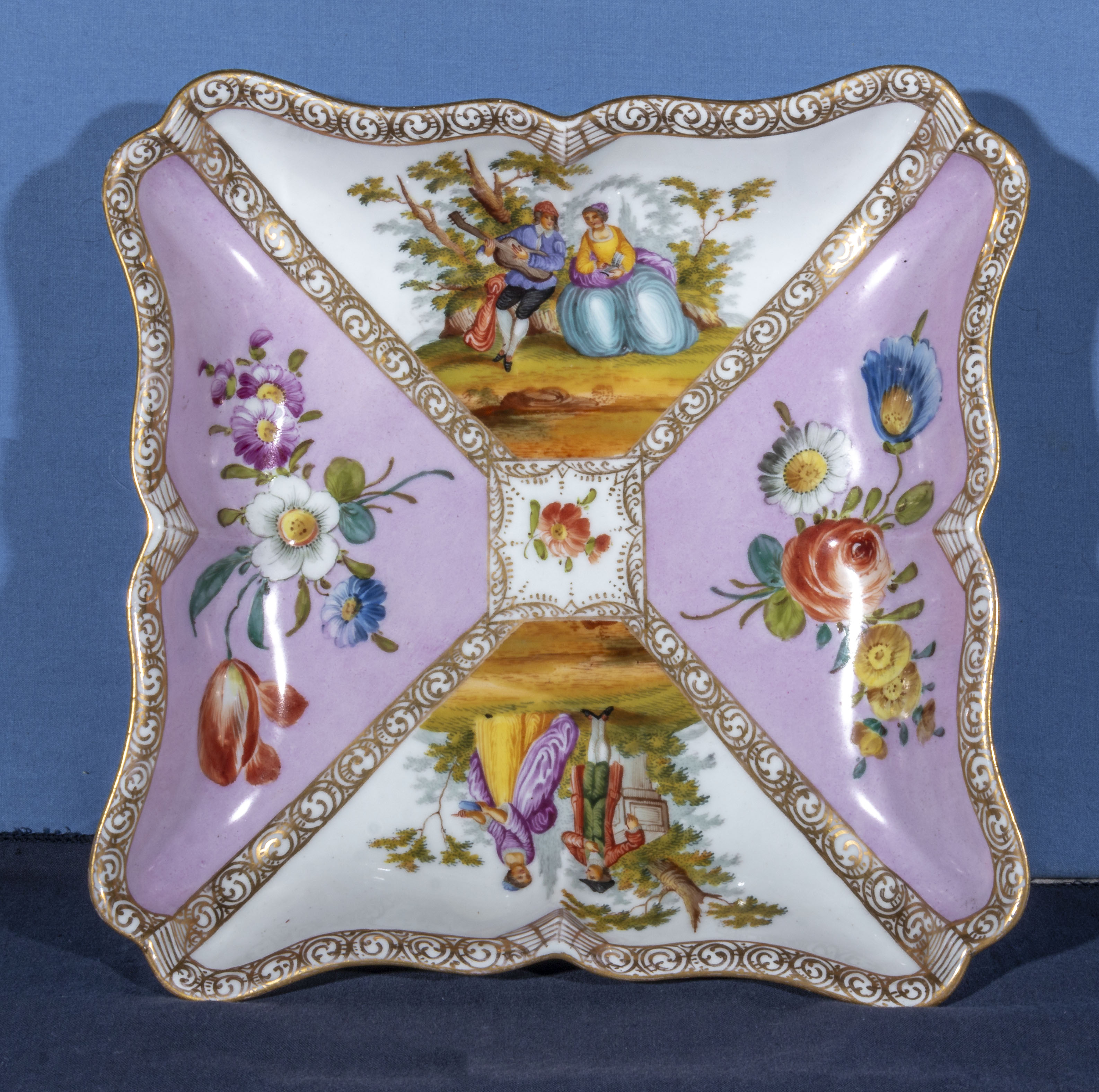 An antique porcelain Augustus Rex Dresden square shaped dish, decorated in panels with a courting