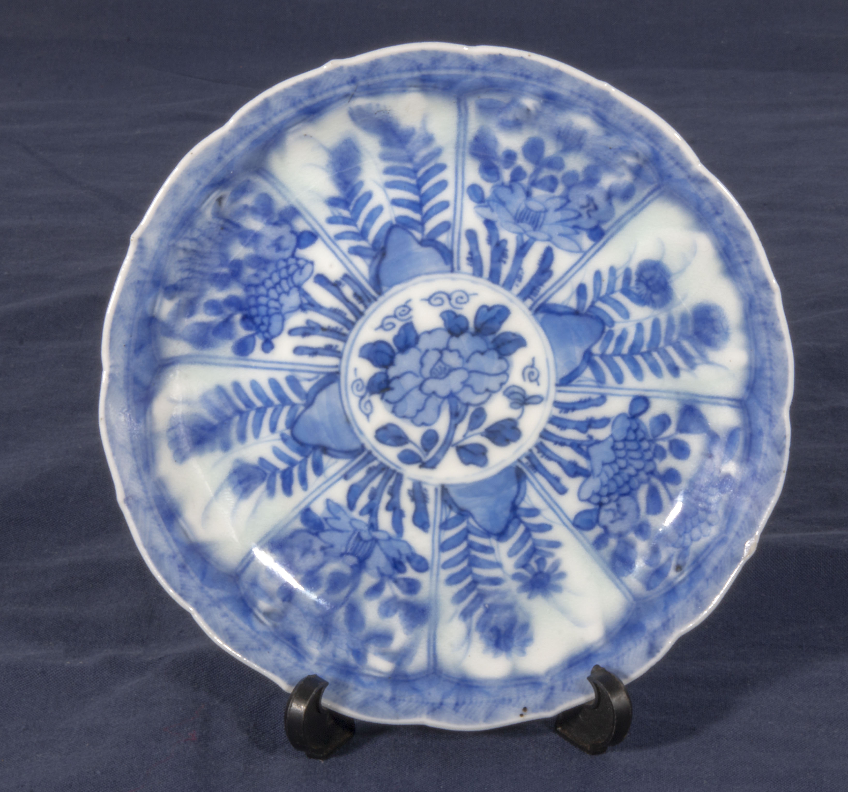 An antique Chinese blue and white decorated dish depicting flowers in panels, double ring mark and