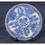 An antique Chinese blue and white decorated dish depicting flowers in panels, double ring mark and