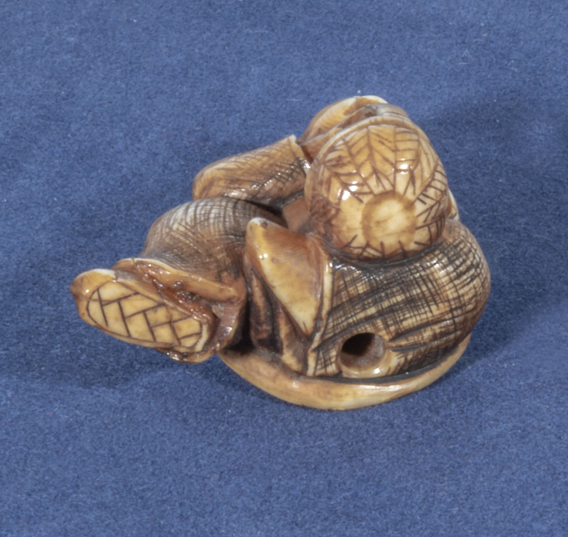An antique netsuke depicting a man with small horn roundells onlaid on his head carrying a basket, - Image 3 of 3