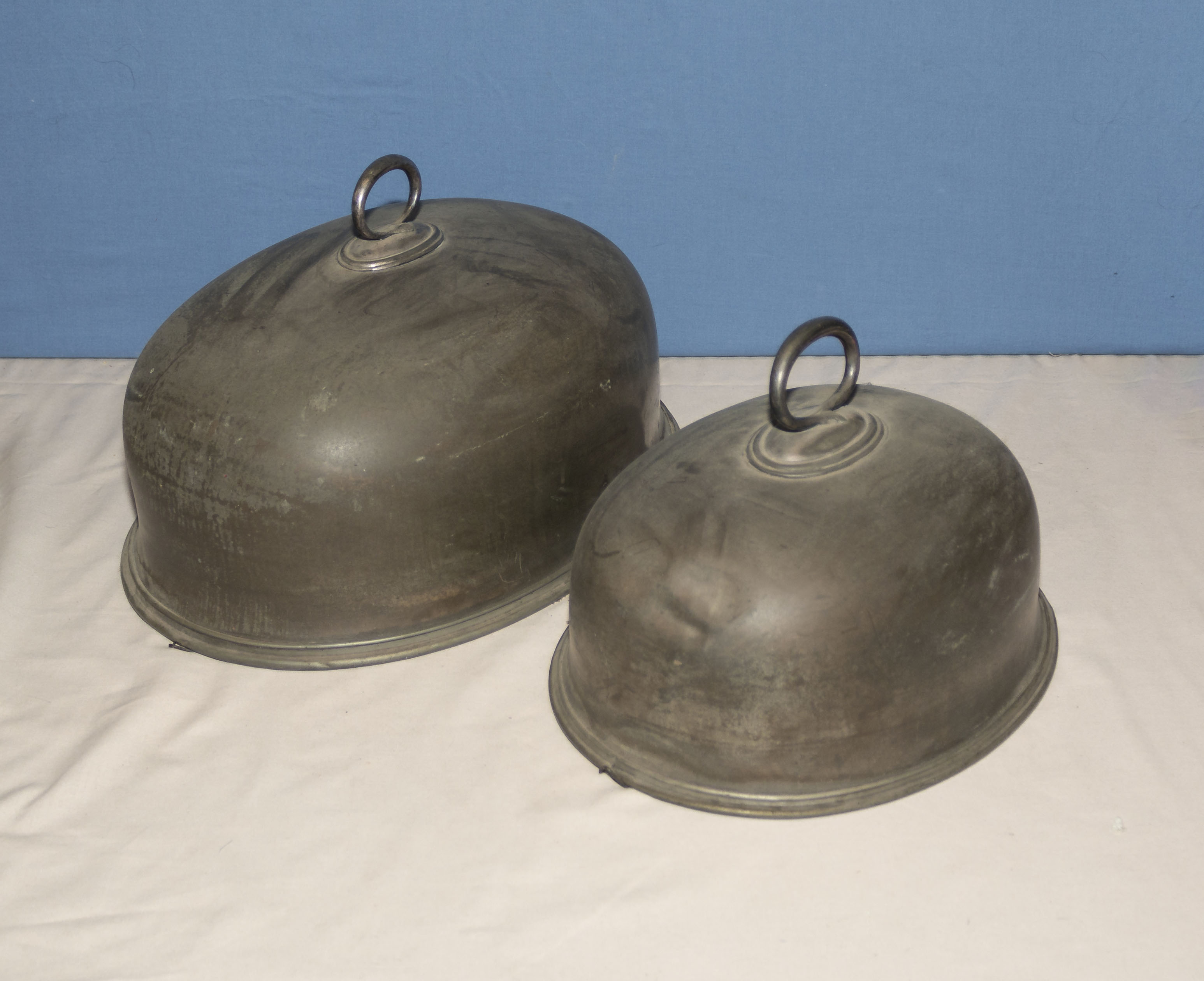 Two pewter meat covers, 40cm and 30cm