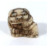 An antique Japanese ivory netsuke meiji period, depicting a boy dressed in a dragon outfit, with